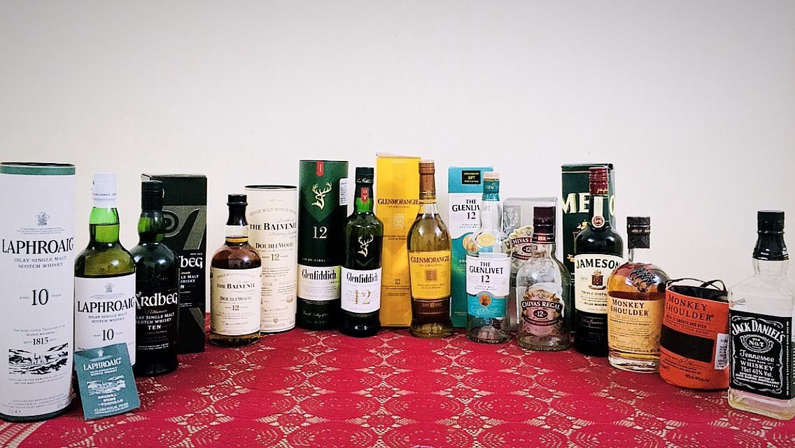 An old photograph of my personal home bar displaying a Scotch-heavy selection of whisky bottles and presentation boxes
